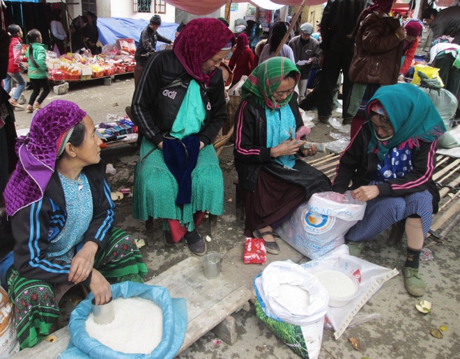 Những người phụ nữ Mông trong bộ váy áo xúng xính cũng dậy thật sớm, địu những bao tải gạo nương trên lưng để kịp buổi chợ. Họ không nói thách hay mặc cả, chỉ ưng cái bụng là mua bán trao đổi với nhau.