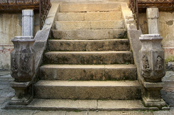 Hai cột bên thành cầu thang đi lên được khắc chạm những hình tượng tôn giáo