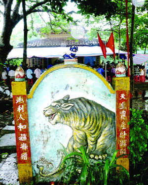 Bức bình phong tạc hình hổ đặt trước đình Tân Hưng, phía sau bình phong là bàn thờ thần Nông