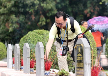 Một phóng viên người Nhật Bản thắp hương trên mộ phần các liệt sỹ.