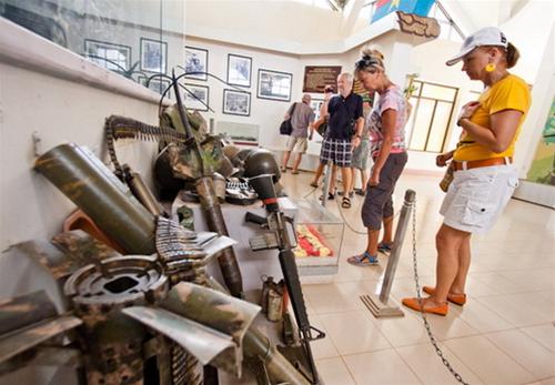 Du khách nước ngoài tham quan những trang bị, vũ khí sót lại của lính Mỹ trong nhà bảo tàng đường 9 - Khe Sanh - Ảnh: Tiến Thành